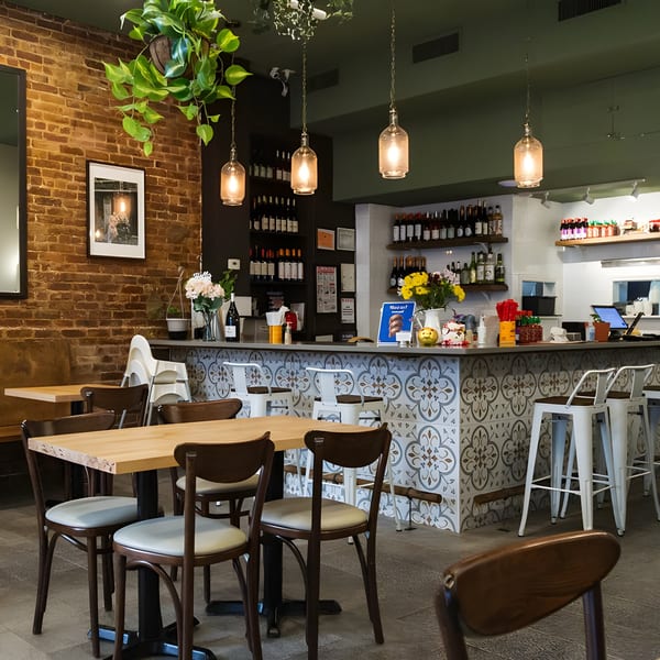 Plum Vietnamese Restaurant interior with brick walls, wooden tables, and a tiled bar area.