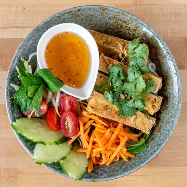Plum Vietnamese Restaurant's vermicelli bowl with fried tofu, fresh vegetables, and a side of sauce.